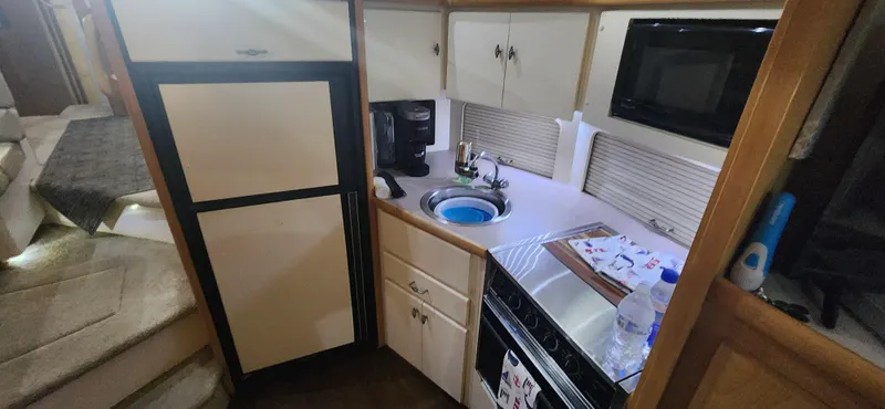 Slide: The Image of Compact kitchen in a 1996 Carver 400 Cockpit Motor Yacht with appliances and storage. - 18