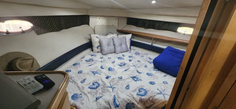 Slide: The Image of Cozy bedroom in 1996 Carver 400 Cockpit Motor Yacht with nautical-themed bedding. - 19
