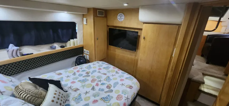 Slide: The Image of Interior of 1996 Carver 400 Cockpit Motor Yacht bedroom with cozy decor and TV. - 22