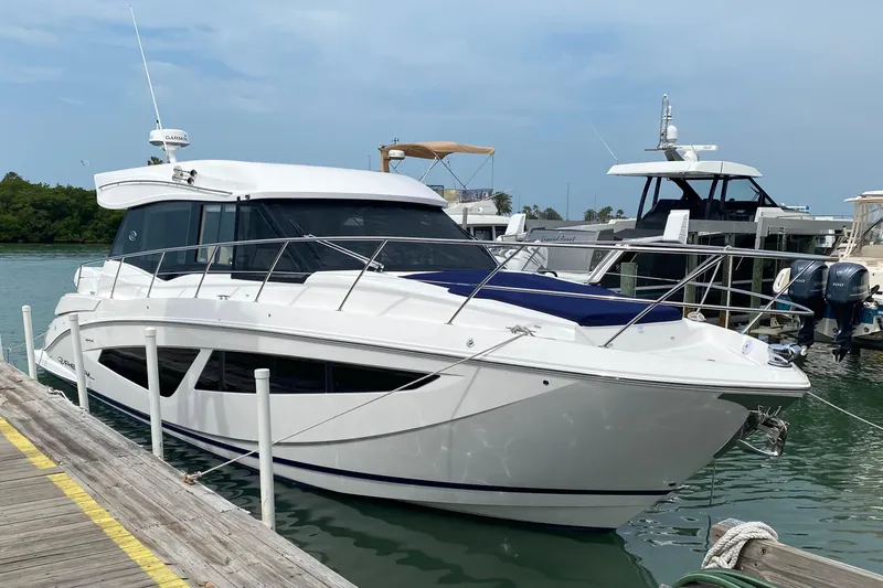 The Image of 2021 Regal 42 XO yacht docked at marina, sleek design, white exterior. - 0