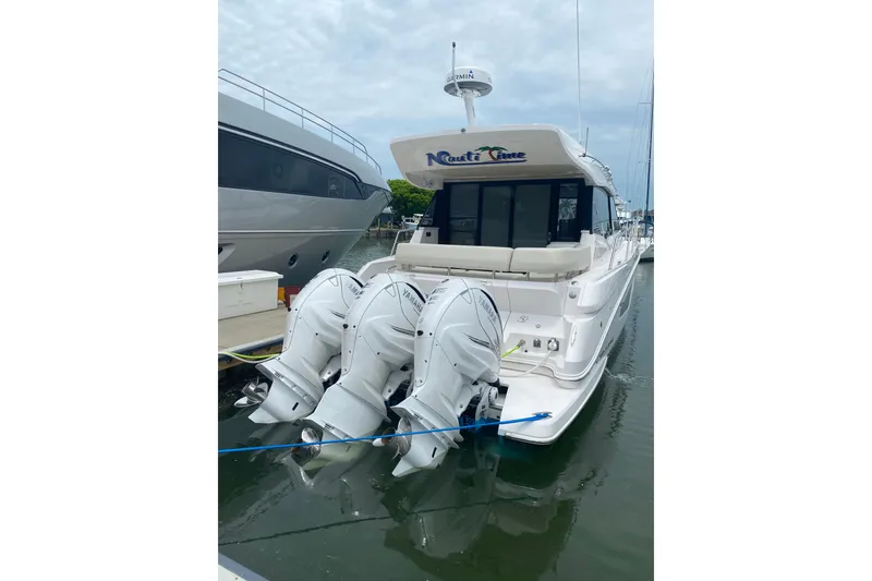 Slide: The Image of 2021 Regal 42 XO yacht docked with triple Yamaha outboard engines. - 13