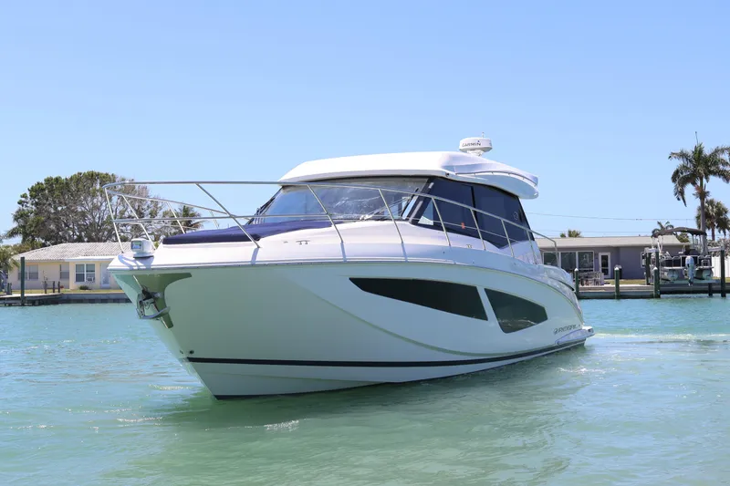 Slide: The Image of 2021 Regal 42 XO yacht docked at night with blue underwater lights. - 20