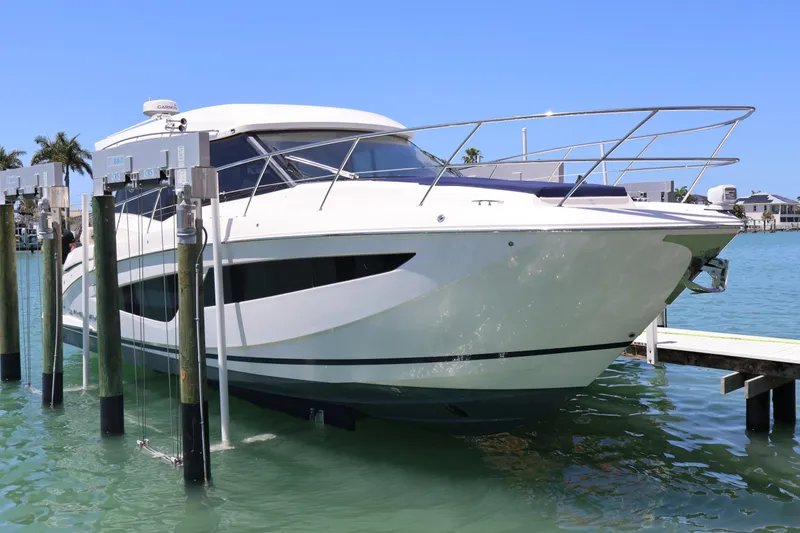 Slide: The Image of Luxurious seating area on 2021 Regal 42 XO yacht with wooden table and cushioned seats. - 28