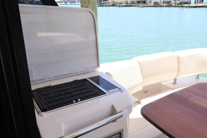 Slide: The Image of 2021 Regal 42 XO interior with white seating and wooden storage cabinet. - 38