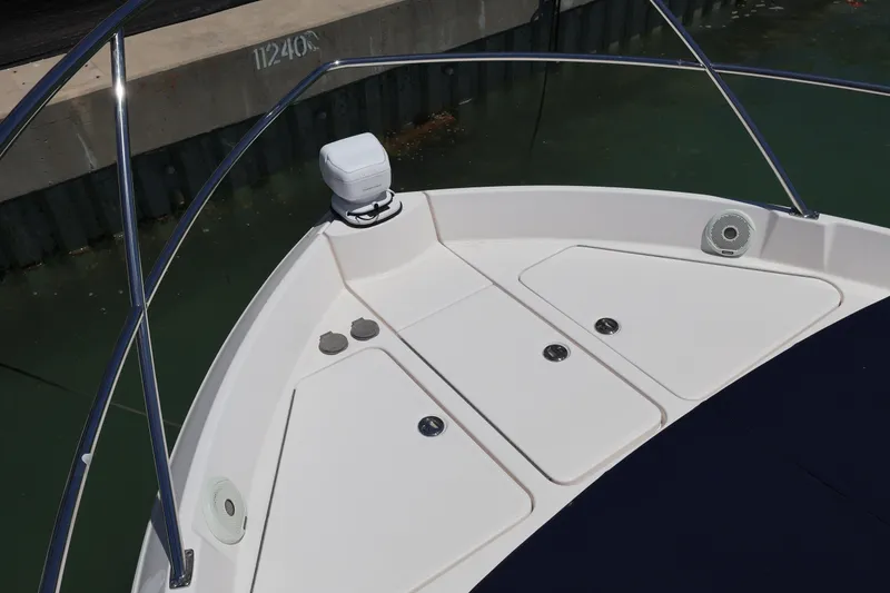 Slide: The Image of 2021 Regal 42 XO yacht docked, featuring sleek windshield and blue cover. - 73