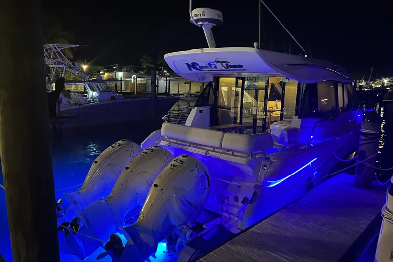 Slide: The Image of 2021 Regal 42 XO yacht docked at night with blue underwater lights. - 8