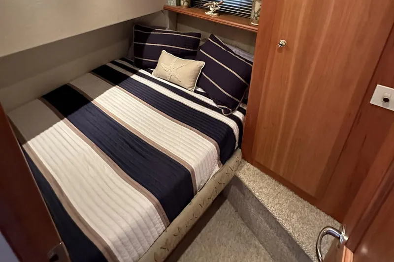 Slide: The Image of Cozy bedroom interior of 2001 Silverton 42 Convertible yacht with striped bedding. - 13