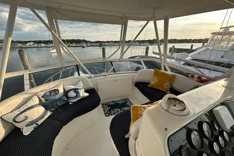 Slide: The Image of Cozy seating area on a 2001 Silverton 42 Convertible yacht, overlooking a serene marina. - 4