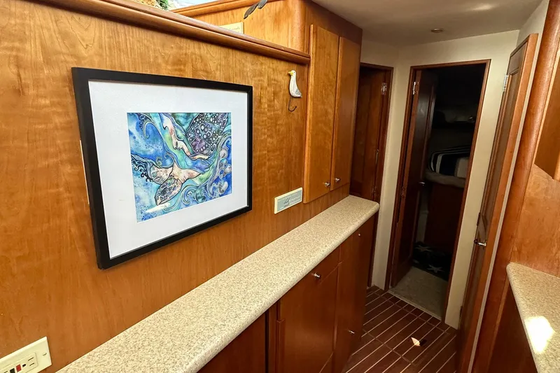 Slide: The Image of Interior hallway of 2001 Silverton 42 Convertible yacht with artwork and wooden cabinetry. - 7