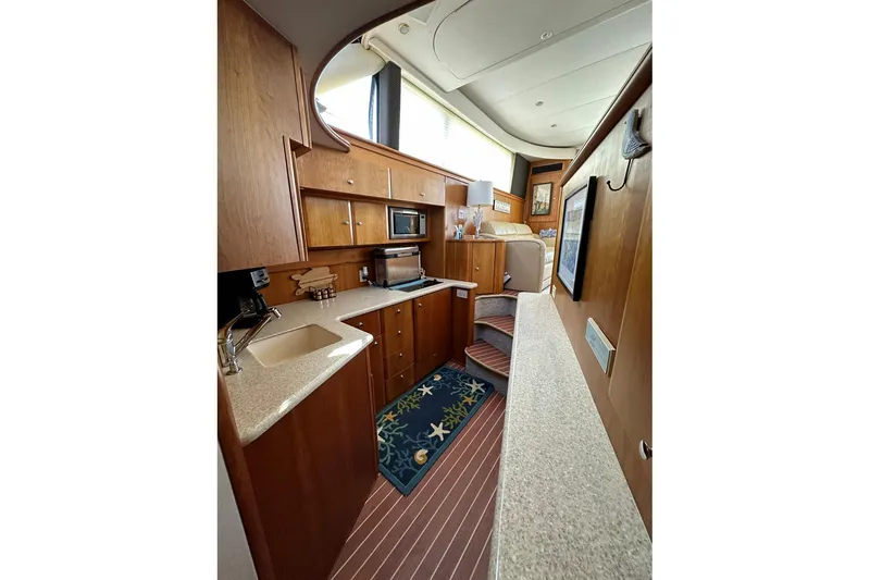 Slide: The Image of Interior of 2001 Silverton 42 Convertible yacht with modern kitchen and wooden cabinetry. - 8
