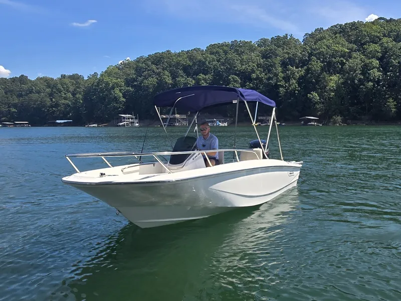 Slide: The Image of A 2026 Boston Whaler 160 Super Sport on a calm lake with a wooded shoreline. - 20