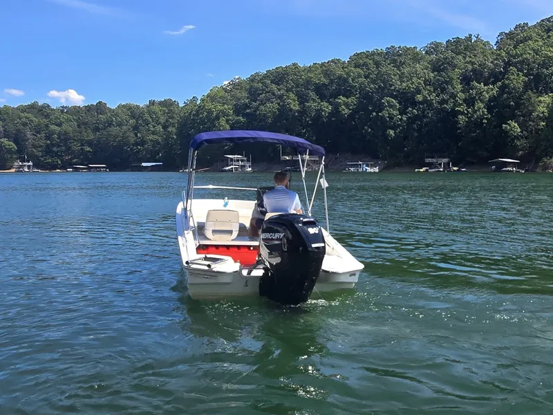 Slide: The Image of A 2026 Boston Whaler 160 Super Sport on a calm lake with wooded shores. - 5