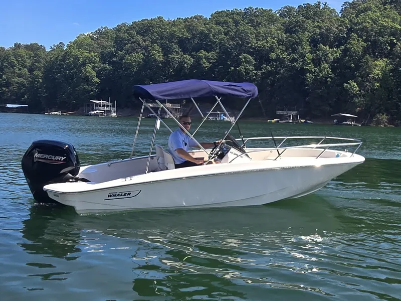 Slide: The Image of A 2026 Boston Whaler 160 Super Sport on a calm lake with a wooded shoreline. - 4