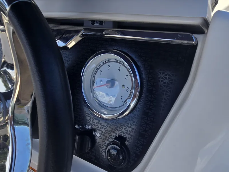 Slide: The Image of Close-up of a boat instrument panel featuring a tachometer and ignition switch. - 12