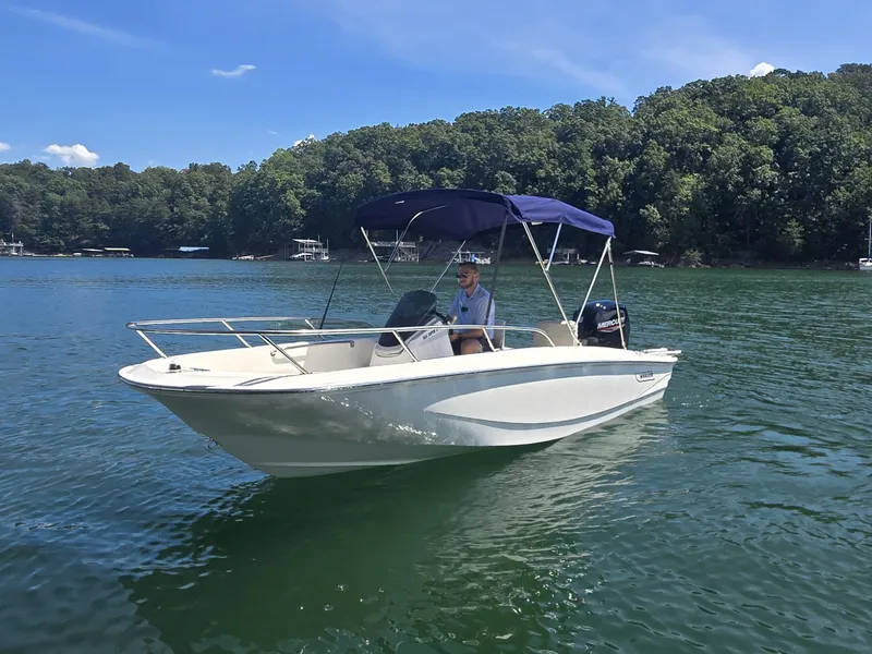 Slide: The Image of A 2026 Boston Whaler 160 Super Sport on a calm lake with a wooded shoreline. - 1