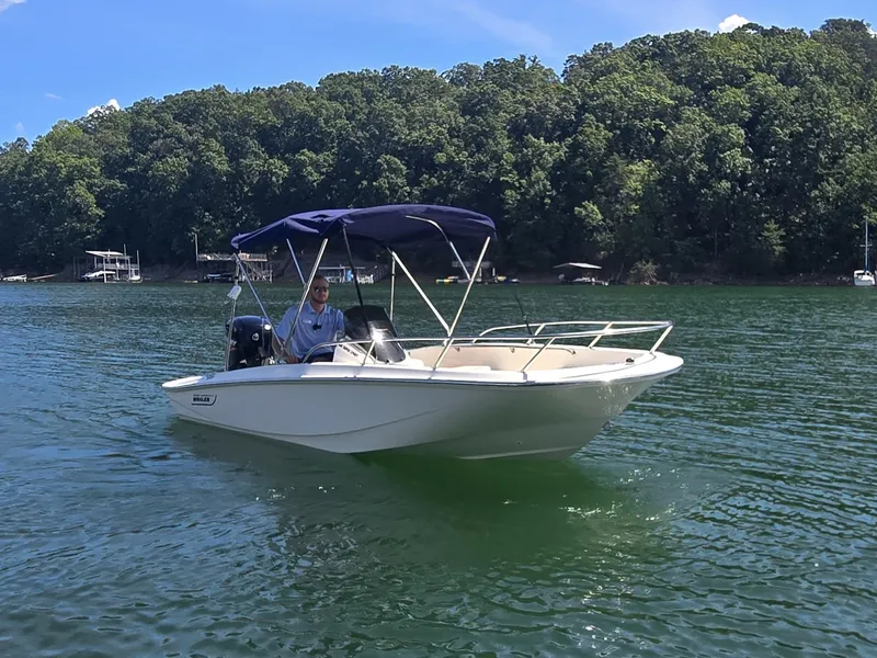 Slide: The Image of A 2026 Boston Whaler 160 Super Sport on a calm lake with a wooded shoreline. - 3