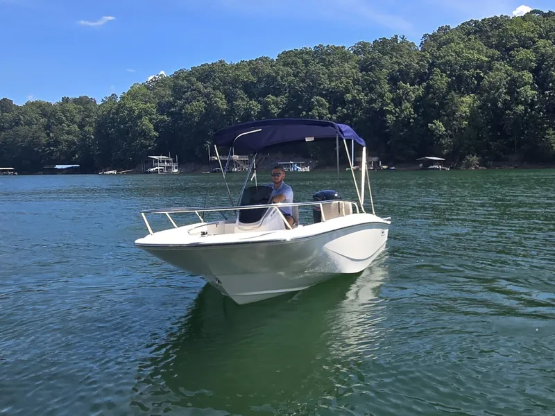 Slide: The Image of A 2026 Boston Whaler 160 Super Sport on a calm lake with wooded shores. - 19