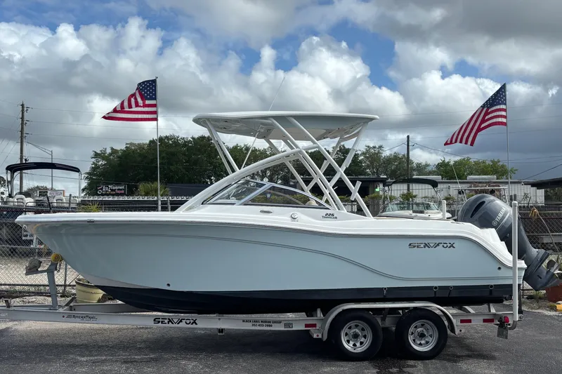 The Image of 2019 Sea Fox 226 Traveler boat on trailer with American flags in background. - 0