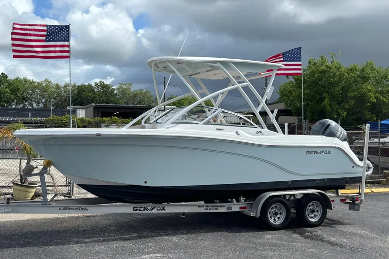 Slide: The Image of 2019 Sea Fox 226 Traveler boat on trailer with American flags in background. - 11