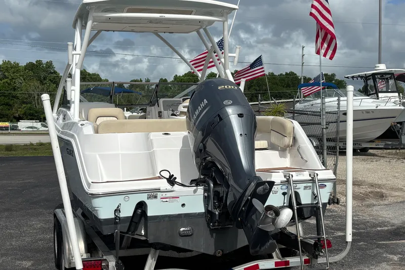 Slide: The Image of 2019 Sea Fox 226 Traveler boat with Yamaha engine, displayed outdoors with American flags. - 2