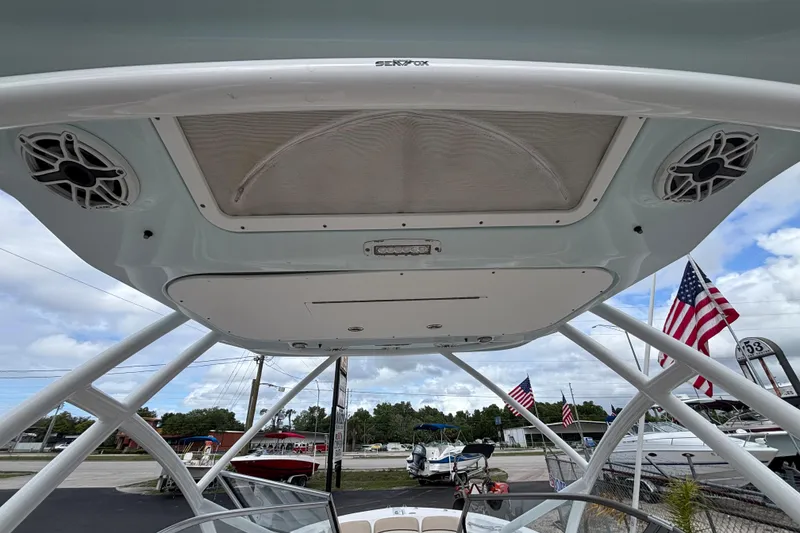 Slide: The Image of 2019 Sea Fox 226 Traveler boat with T-top and speakers, American flags in background. - 36