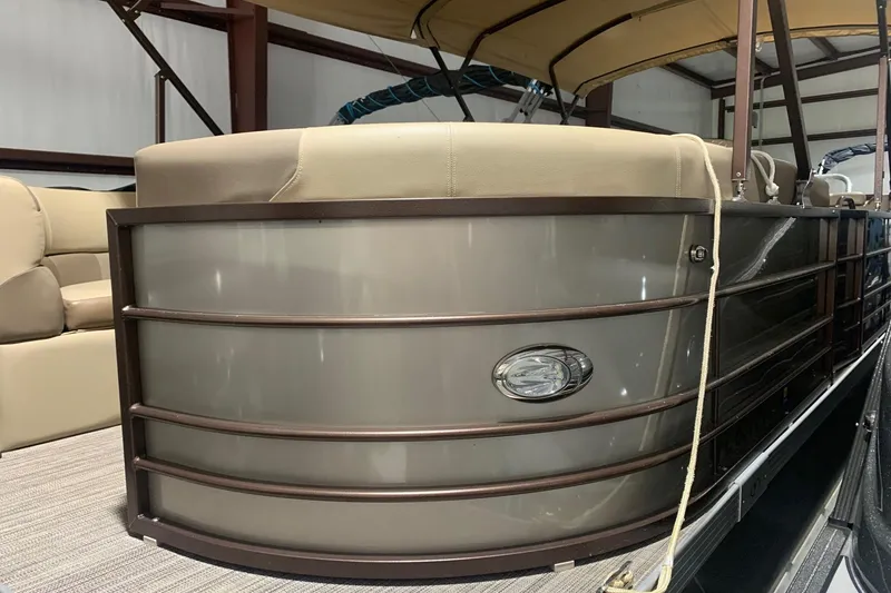 Slide: The Image of 2019 Veranda Relax VR25RC pontoon boat with beige seating and brown railing. - 2