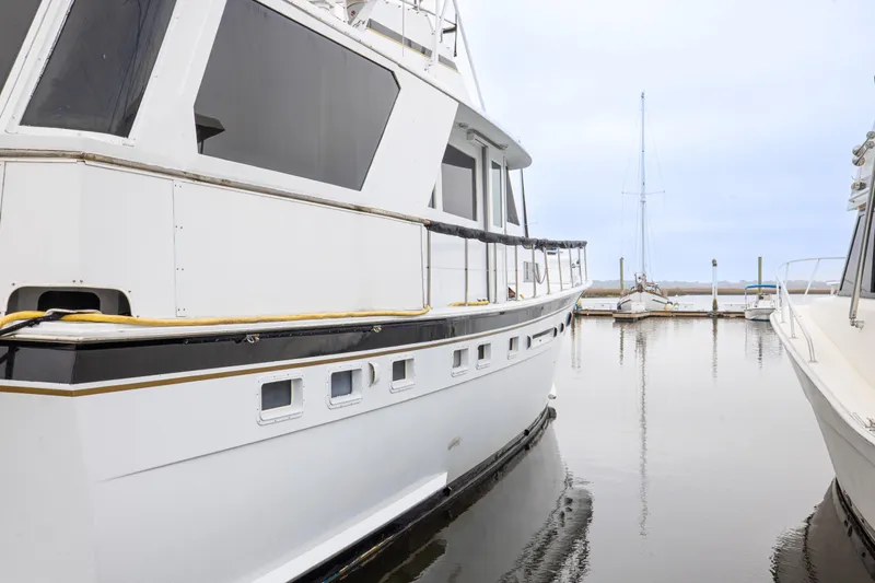 Slide: The Image of 1980 Hatteras 53 Motor Yacht docked in a serene marina setting. - 18