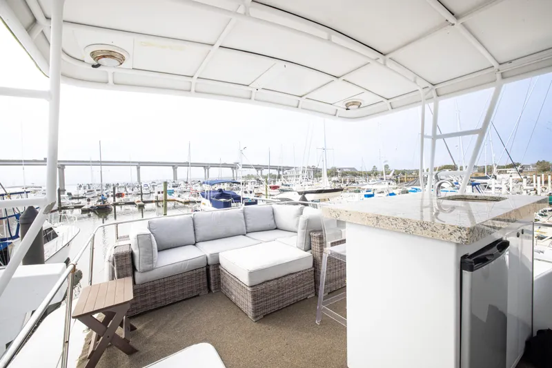 Slide: The Image of Luxurious 1980 Hatteras 53 Motor Yacht deck with seating and marina view. - 24