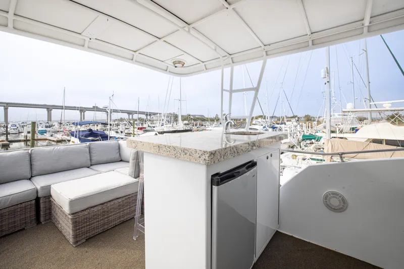 Slide: The Image of 1980 Hatteras 53 Motor Yacht deck with seating, bar, and marina view. - 26