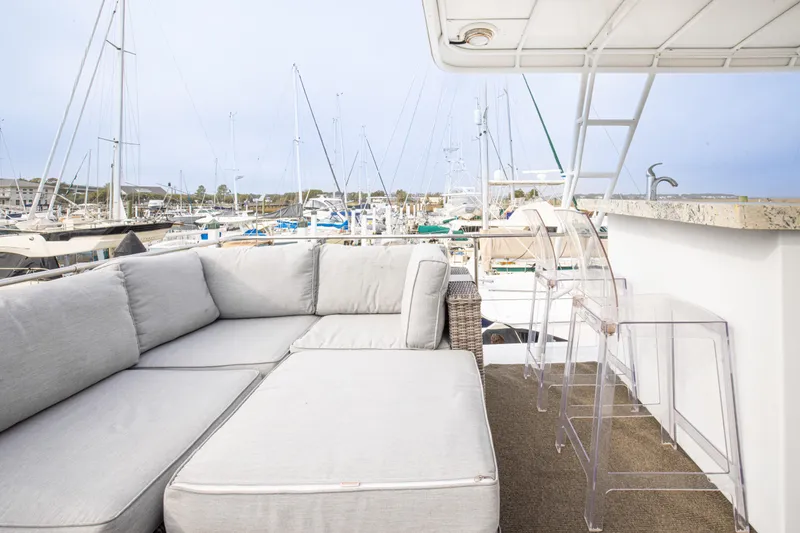 Slide: The Image of Luxurious deck of 1980 Hatteras 53 Motor Yacht with seating and marina view. - 30