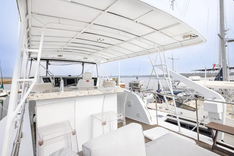 Slide: The Image of 1980 Hatteras 53 Motor Yacht deck with seating and helm, docked at marina. - 33