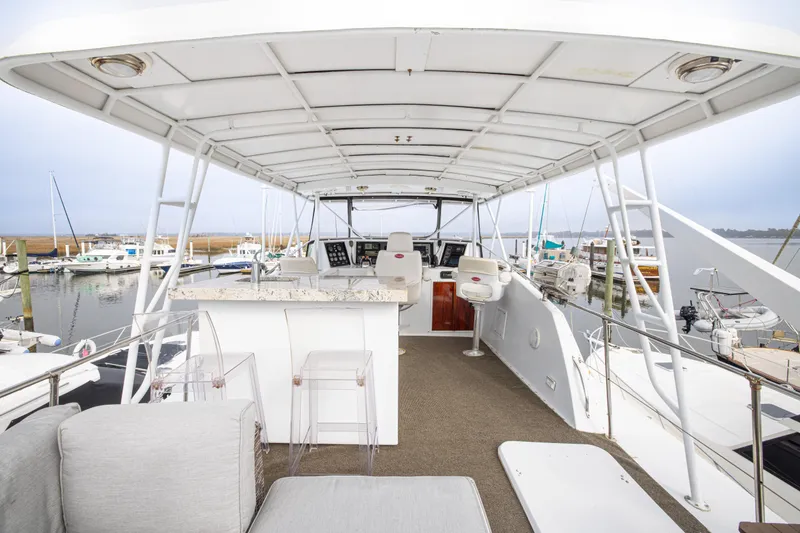 Slide: The Image of 1980 Hatteras 53 Motor Yacht deck with seating and helm, docked at marina. - 34