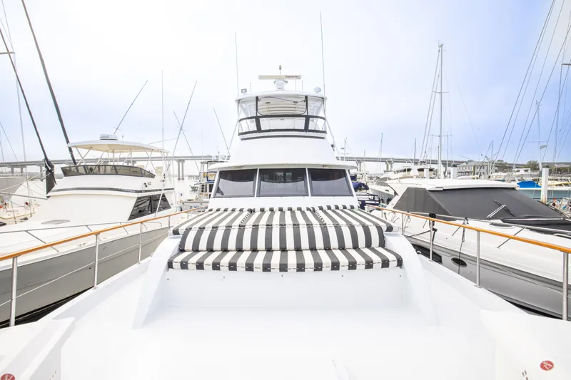Slide: The Image of 1980 Hatteras 53 Motor Yacht docked, featuring striped sunbed and sleek design. - 35