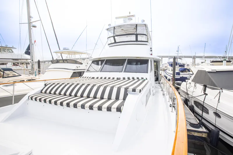 Slide: The Image of 1980 Hatteras 53 Motor Yacht docked, featuring striped sunbed and sleek design. - 36
