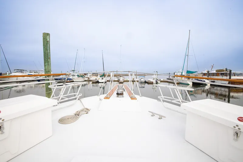 Slide: The Image of 1980 Hatteras 53 Motor Yacht docked in a marina, surrounded by sailboats. - 39