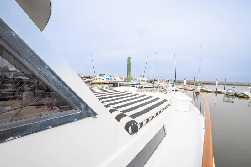Slide: The Image of 1980 Hatteras 53 Motor Yacht docked at marina with striped deck cover. - 41