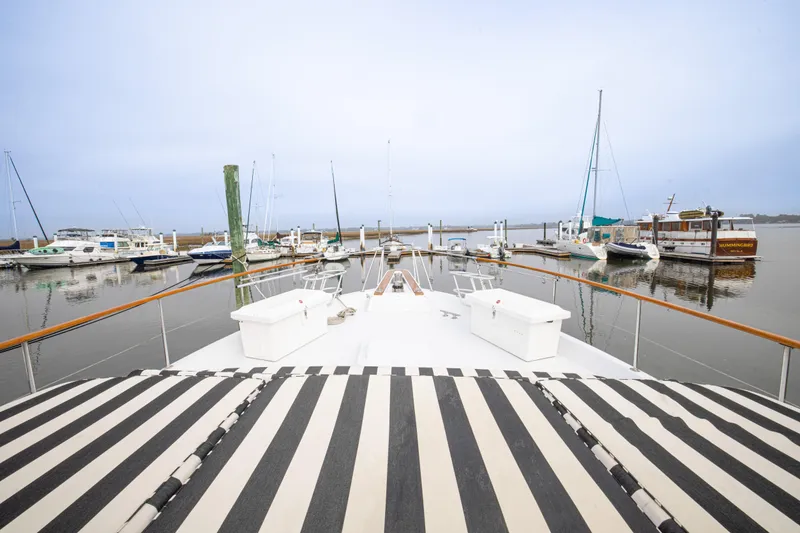 Slide: The Image of 1980 Hatteras 53 Motor Yacht docked at marina with striped deck cover. - 42