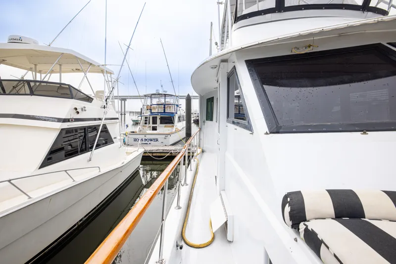 Slide: The Image of 1980 Hatteras 53 Motor Yacht docked alongside other boats in a marina. - 44