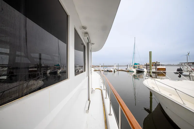 Slide: The Image of 1980 Hatteras 53 Motor Yacht docked at marina, showcasing sleek design and reflective windows. - 45