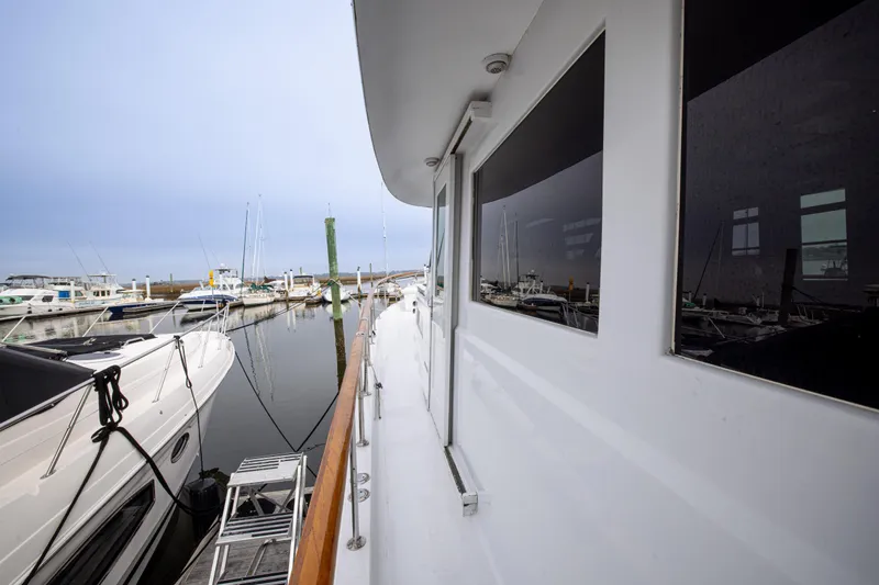Slide: The Image of 1980 Hatteras 53 Motor Yacht docked at marina, side view with reflections. - 49