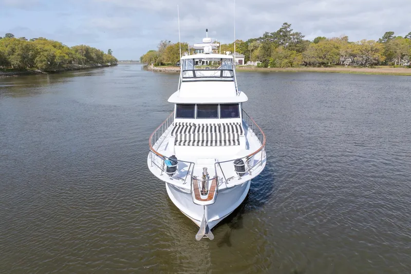 Slide: The Image of 1980 Hatteras 53 Motor Yacht cruising on a serene river with lush greenery. - 5