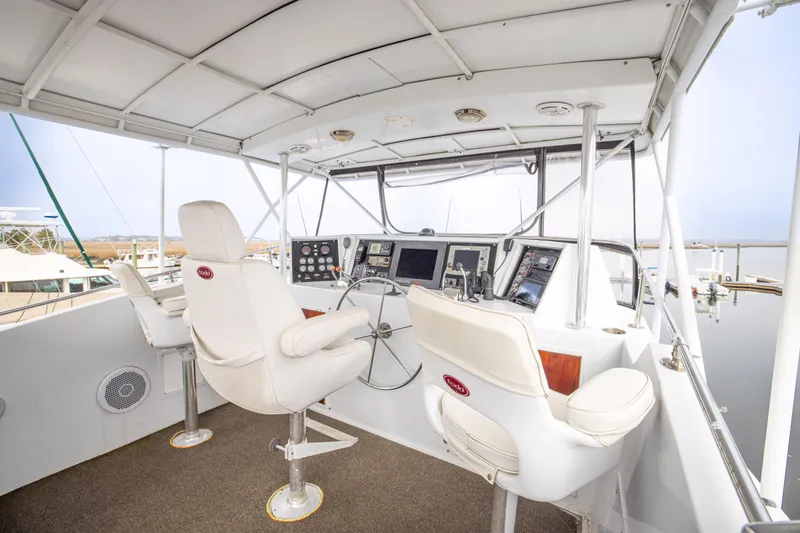 Slide: The Image of Interior helm of 1980 Hatteras 53 Motor Yacht with steering wheel and navigation controls. - 56