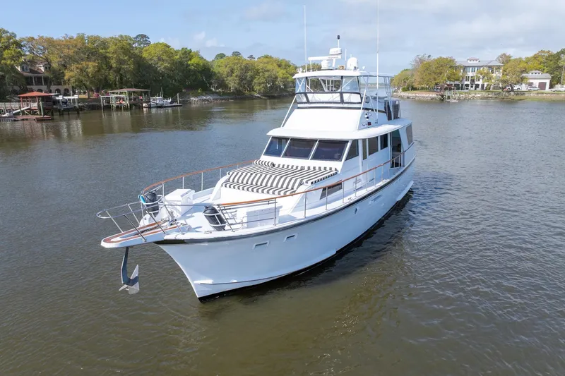 Slide: The Image of 1980 Hatteras 53 Motor Yacht on calm river with scenic background. - 6