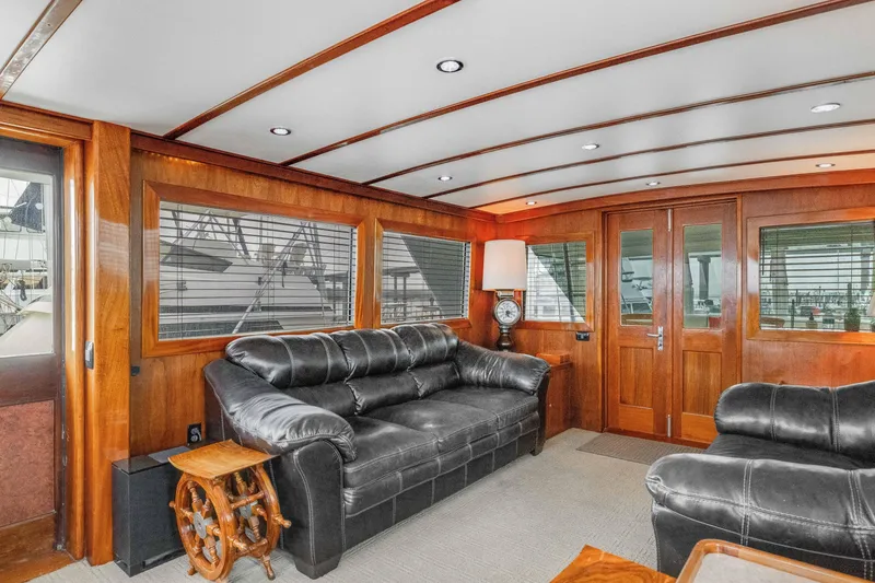 Slide: The Image of Luxurious interior of a 1980 Hatteras 53 Motor Yacht with leather sofas and wooden accents. - 60
