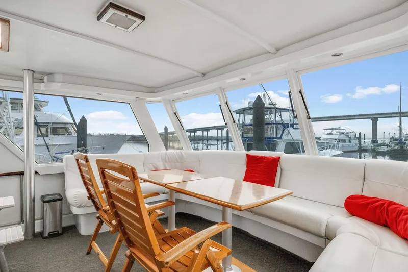 Slide: The Image of Interior of 1980 Hatteras 53 Motor Yacht with white seating and wooden table. - 66