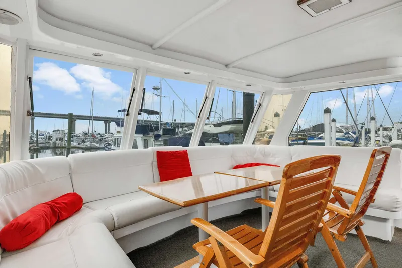 Slide: The Image of Interior of 1980 Hatteras 53 Motor Yacht with white seating and wooden chairs. - 67