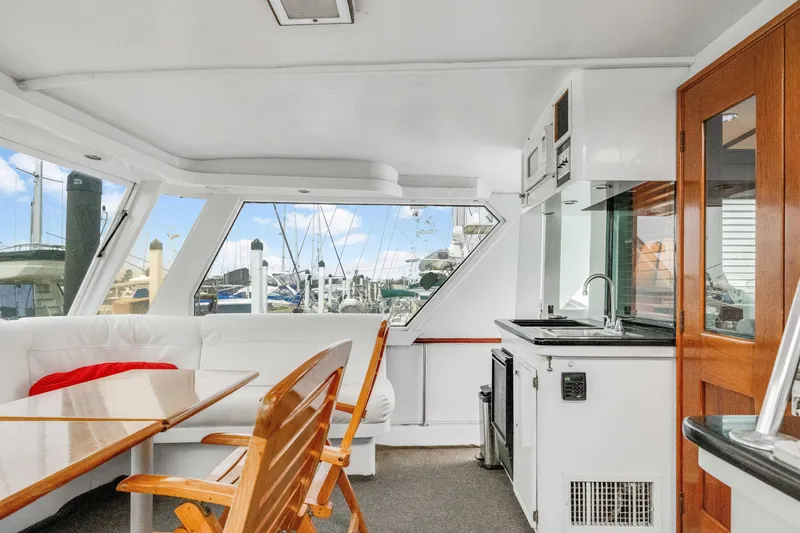 Slide: The Image of Interior of 1980 Hatteras 53 Motor Yacht with seating, table, and kitchenette. - 68