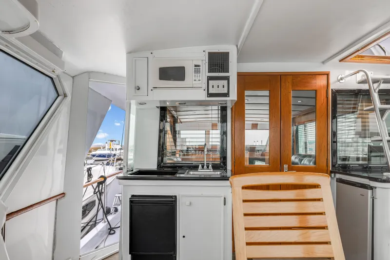 Slide: The Image of 1980 Hatteras 53 Motor Yacht interior with kitchenette and wooden accents. - 72