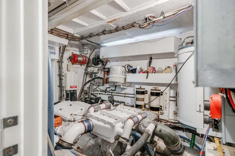Slide: The Image of Engine room of a 1980 Hatteras 53 Motor Yacht, showcasing mechanical components and wiring. - 80