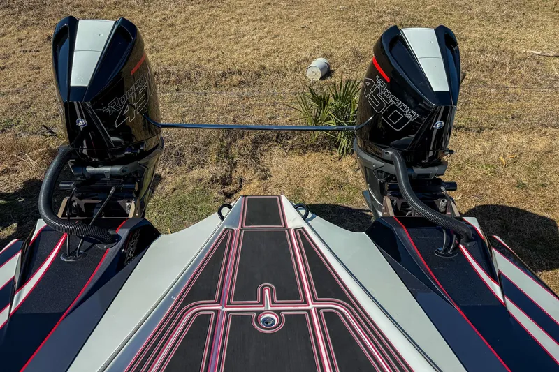 Slide: The Image of 2018 MTI 340X boat with twin Mercury Racing 450 engines, parked on grass. - 11